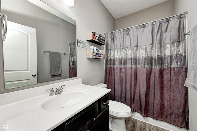 bathroom featuring vanity, wood-type flooring, a textured ceiling, and toilet