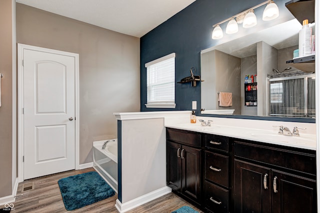 bathroom with hardwood / wood-style flooring, vanity, and a bathing tub