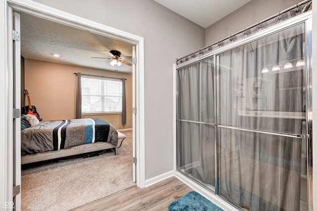 bathroom featuring a textured ceiling, hardwood / wood-style flooring, and ceiling fan