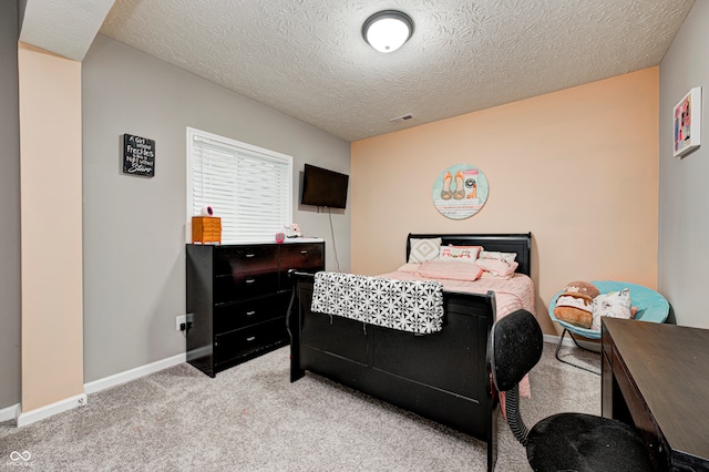 bedroom featuring a textured ceiling and light colored carpet