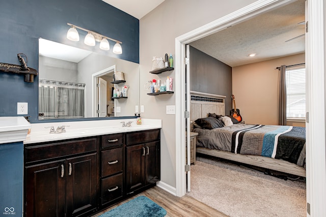 bathroom with vanity, wood-type flooring, and a textured ceiling