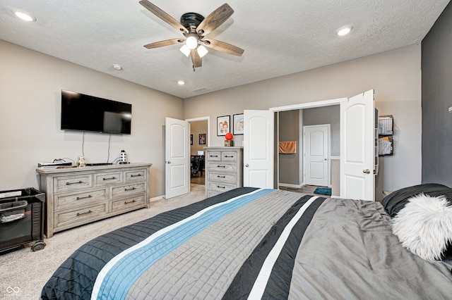 carpeted bedroom with ceiling fan and a textured ceiling