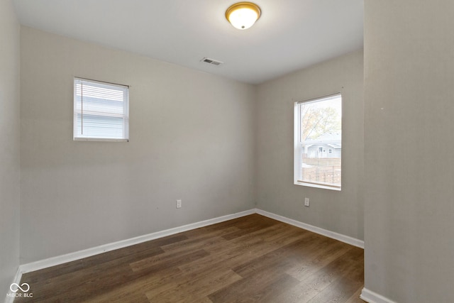 empty room with dark hardwood / wood-style flooring