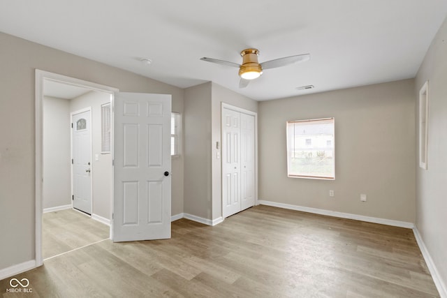 unfurnished bedroom with ceiling fan, light wood-type flooring, and a closet