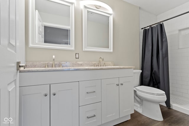 bathroom with vanity, toilet, wood-type flooring, and walk in shower