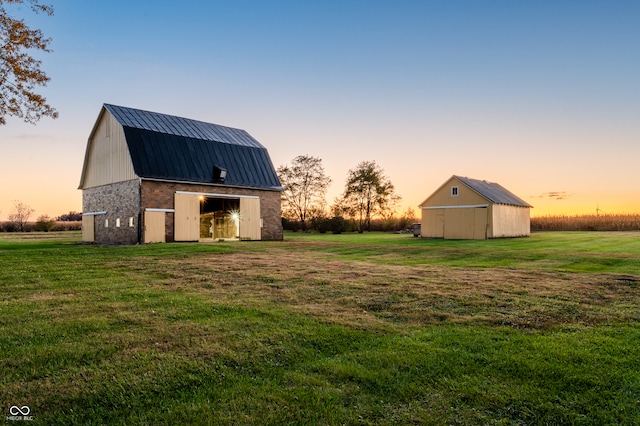 yard at dusk featuring an outdoor structure