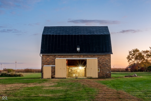 outdoor structure at dusk featuring a lawn