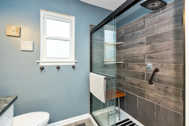 bathroom with wood-type flooring, toilet, and walk in shower