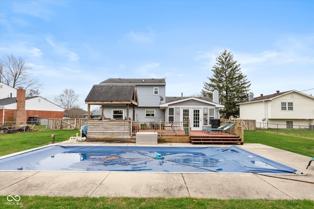 view of pool featuring a yard, a wooden deck, and french doors