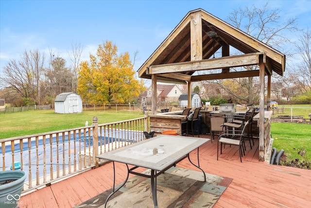 wooden terrace with a gazebo, a yard, a shed, and a covered pool