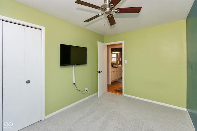 unfurnished bedroom with ceiling fan, light colored carpet, and a closet