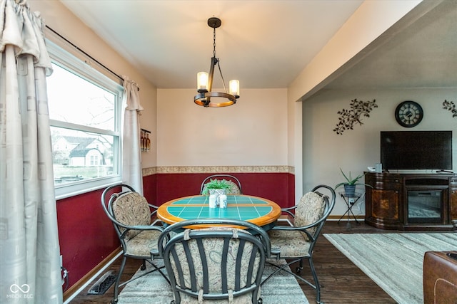 dining space with dark hardwood / wood-style floors and an inviting chandelier