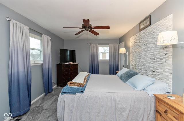 carpeted bedroom featuring multiple windows and ceiling fan