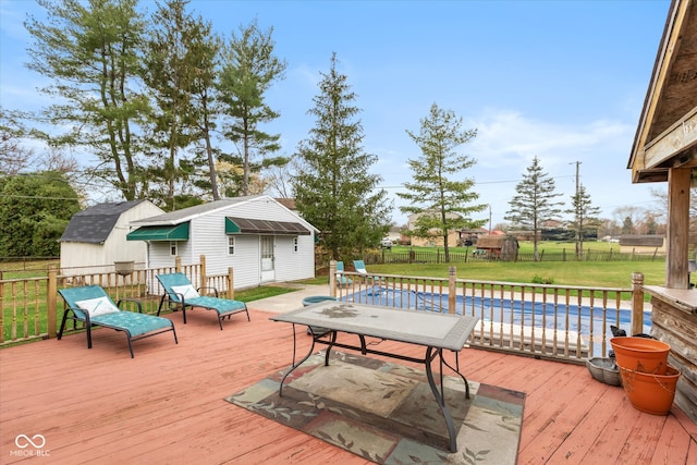 wooden deck with a lawn and a storage unit