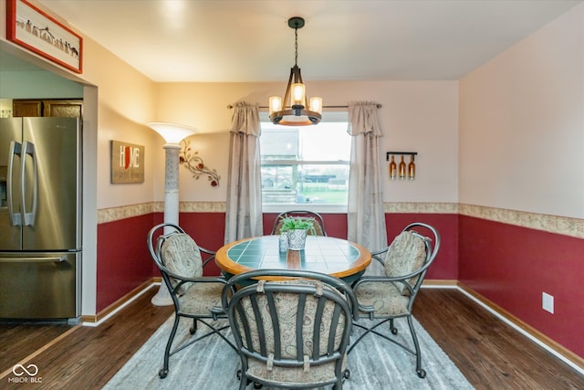 dining space featuring dark hardwood / wood-style flooring and a chandelier