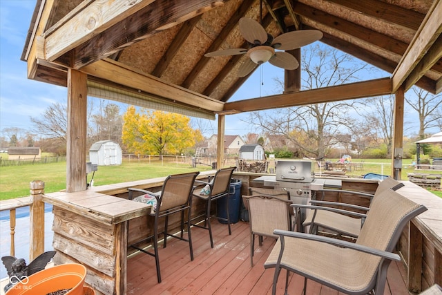 deck with a lawn, ceiling fan, a gazebo, and a shed