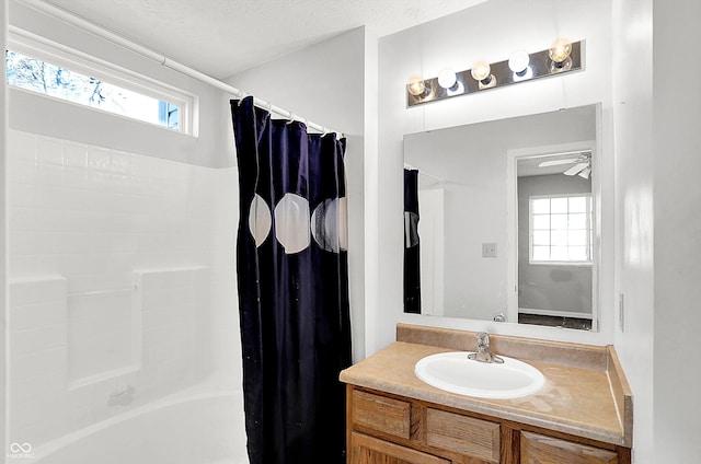 bathroom featuring vanity, shower / bath combo with shower curtain, a textured ceiling, and a wealth of natural light