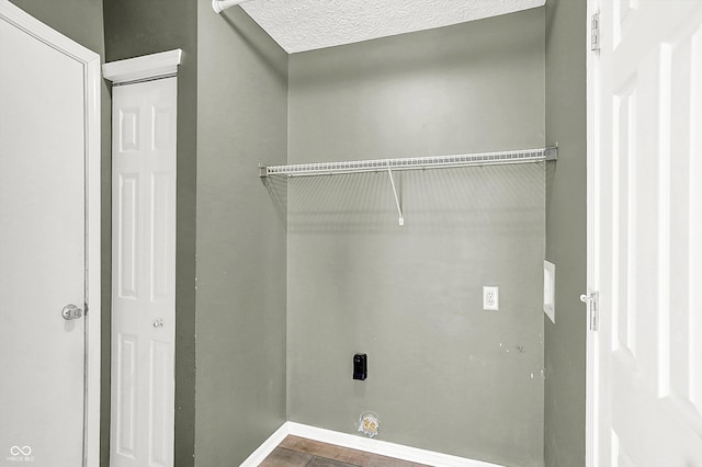 clothes washing area with a textured ceiling and electric dryer hookup