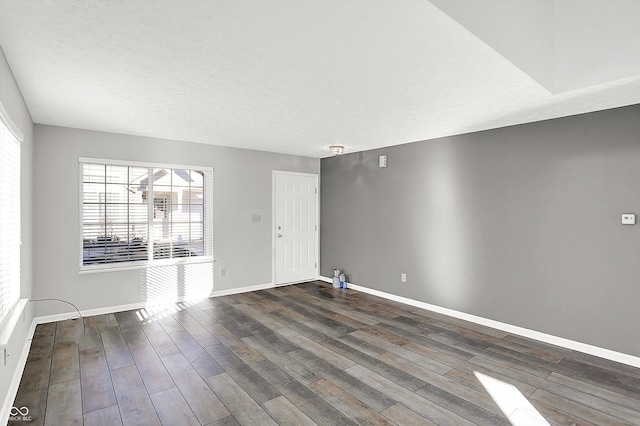 empty room featuring a textured ceiling and dark hardwood / wood-style flooring