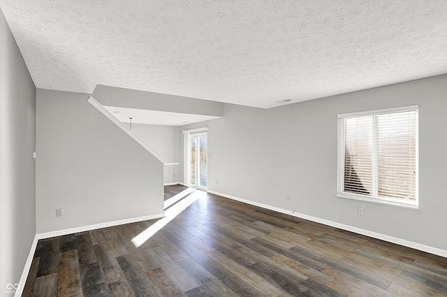 unfurnished room with dark hardwood / wood-style flooring and a textured ceiling