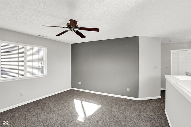 carpeted spare room with a textured ceiling and ceiling fan