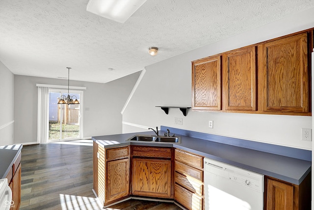 kitchen with sink, an inviting chandelier, dark hardwood / wood-style floors, white dishwasher, and decorative light fixtures