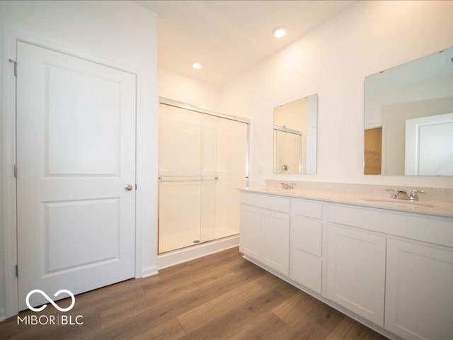 bathroom featuring hardwood / wood-style flooring, vanity, and walk in shower