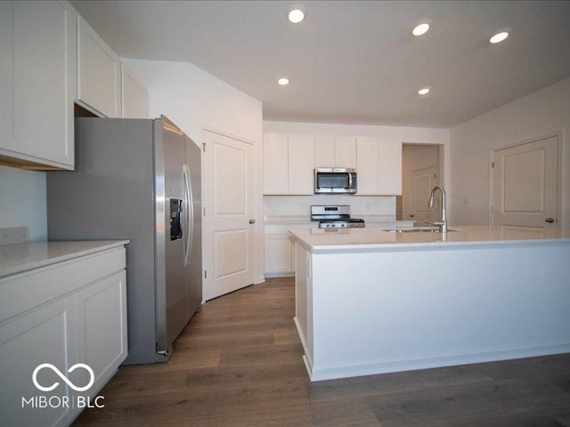 kitchen featuring sink, stainless steel appliances, white cabinets, and a center island with sink