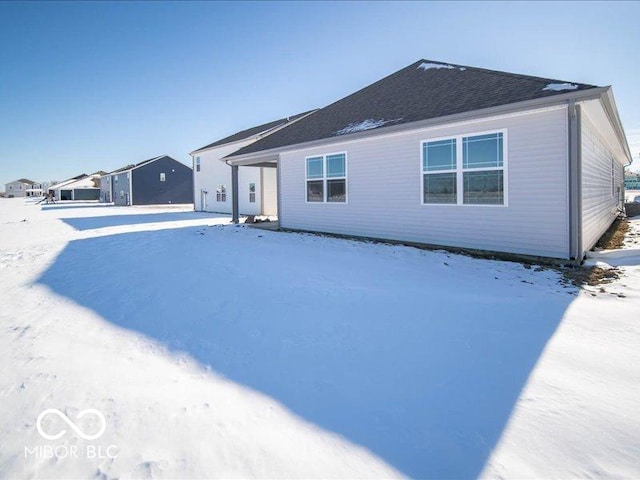 view of snow covered back of property