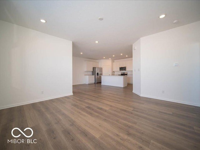 unfurnished living room featuring dark wood-type flooring and sink