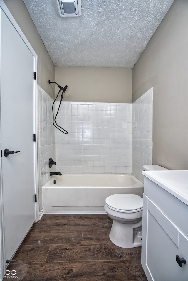 full bathroom with toilet, vanity, a textured ceiling, and hardwood / wood-style flooring