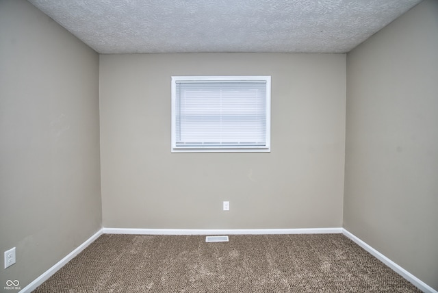 carpeted spare room featuring a textured ceiling