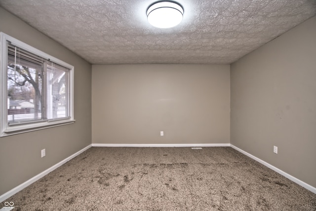 spare room with carpet flooring and a textured ceiling