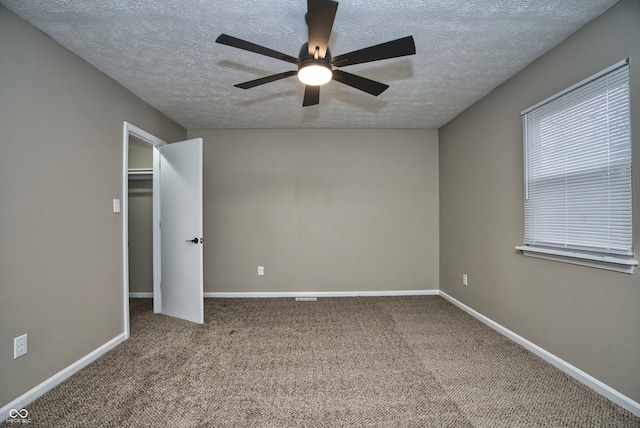 unfurnished bedroom with carpet, a textured ceiling, a closet, and ceiling fan