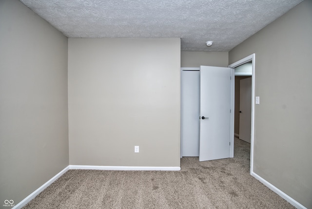 unfurnished bedroom with a textured ceiling and light carpet