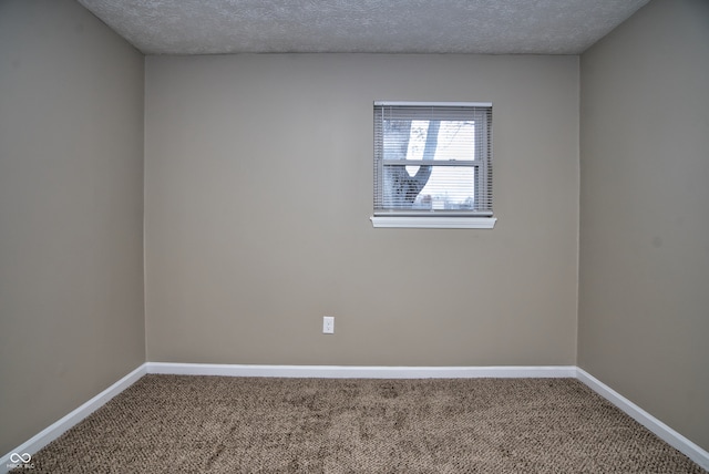 carpeted empty room featuring a textured ceiling