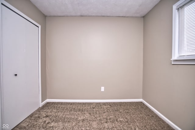 unfurnished bedroom with a textured ceiling and carpet floors