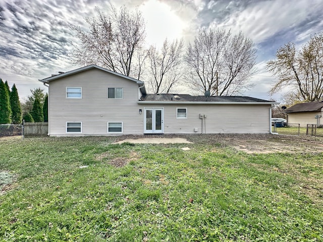 rear view of house featuring french doors and a lawn