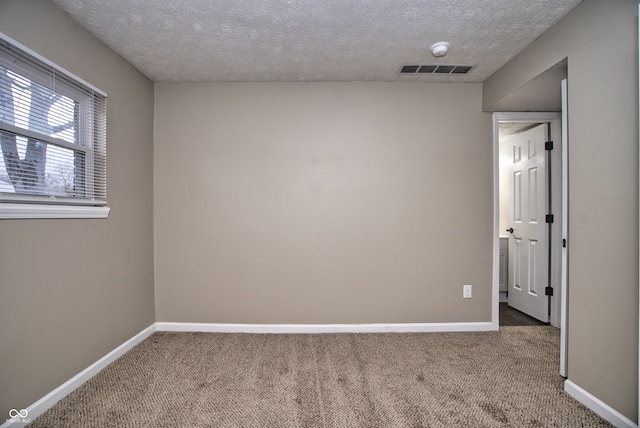 unfurnished room featuring carpet floors and a textured ceiling