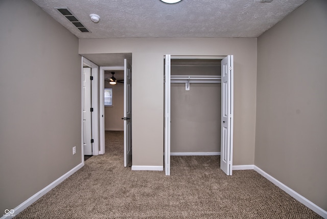 unfurnished bedroom featuring a closet, carpet, and a textured ceiling