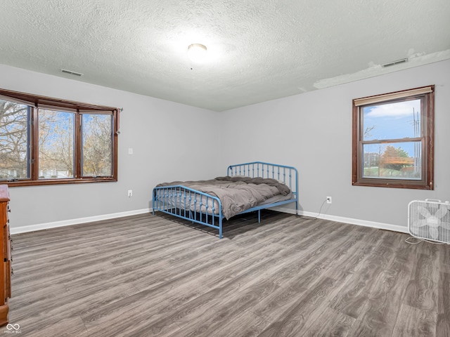 bedroom with wood-type flooring and a textured ceiling