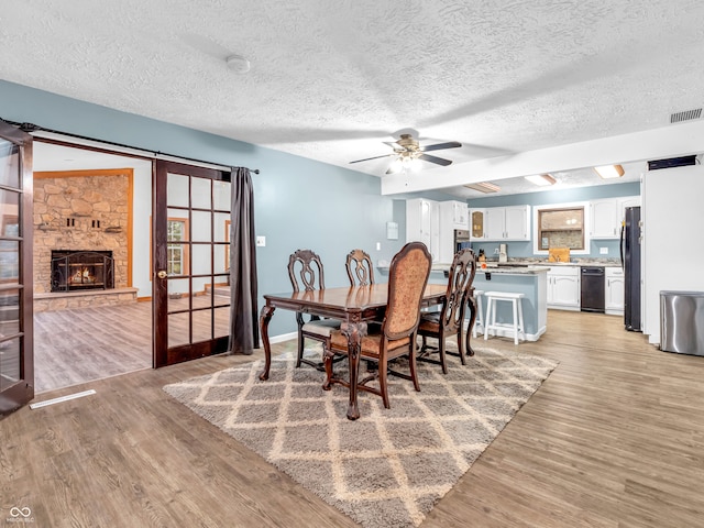 dining space featuring ceiling fan, light hardwood / wood-style floors, and a textured ceiling