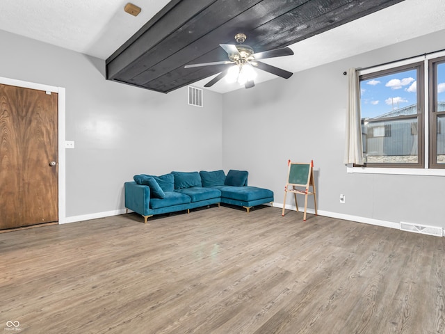 living area with ceiling fan, a textured ceiling, and hardwood / wood-style flooring