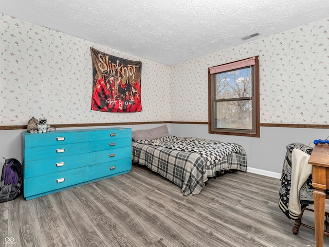 bedroom with hardwood / wood-style floors and a textured ceiling