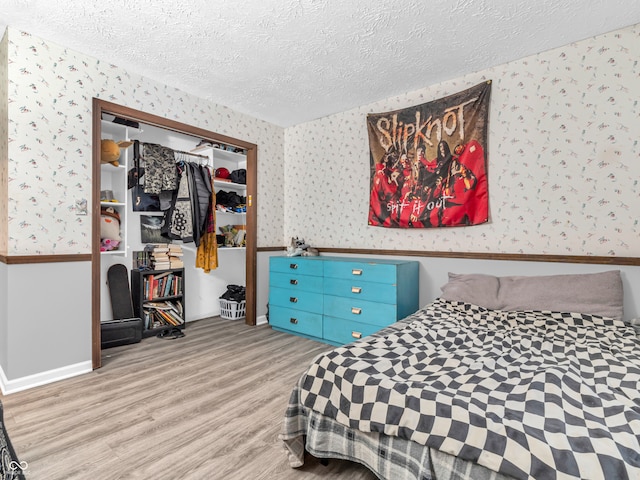 bedroom featuring a closet, light hardwood / wood-style floors, and a textured ceiling