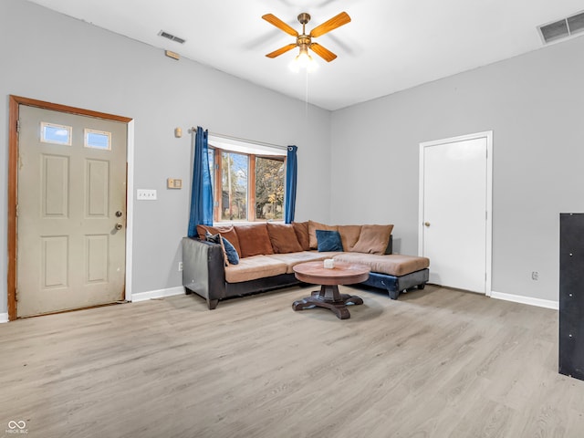 living room with light hardwood / wood-style flooring and ceiling fan