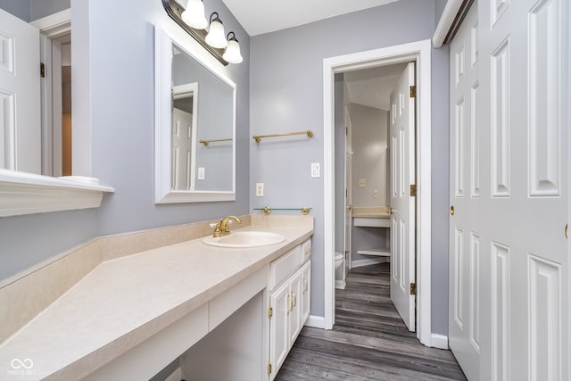 bathroom featuring vanity, hardwood / wood-style flooring, and toilet