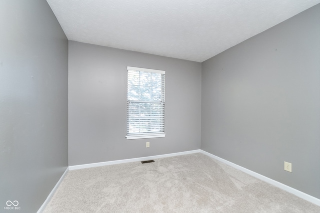 unfurnished room with a textured ceiling and carpet flooring