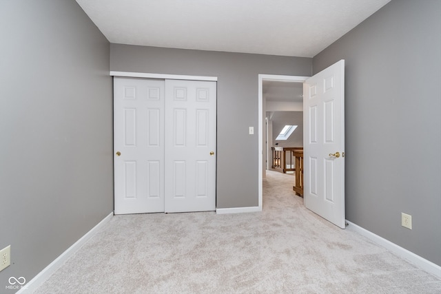 unfurnished bedroom with a closet and light carpet