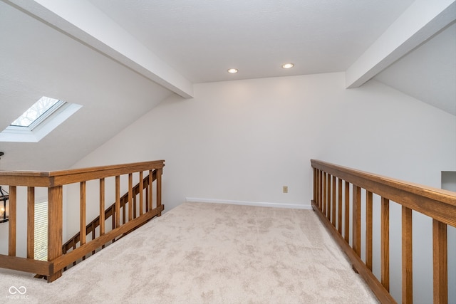 additional living space with vaulted ceiling with skylight and light colored carpet